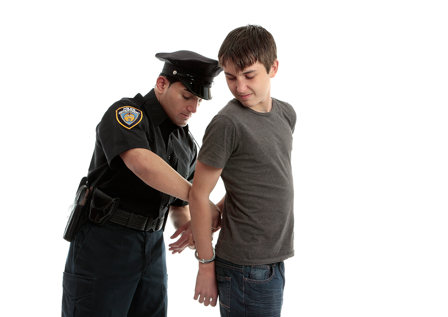 bigstock-Policeman-Handcuffing-Teenager-22787240.jpg